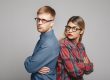 People, love, family, marriage and relationships problems concept. Studio shot of grumpy young woman and bearded man standing back to back to each other and keeping arms crossed after serious fight