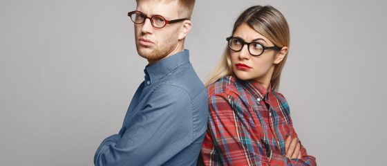 People, love, family, marriage and relationships problems concept. Studio shot of grumpy young woman and bearded man standing back to back to each other and keeping arms crossed after serious fight